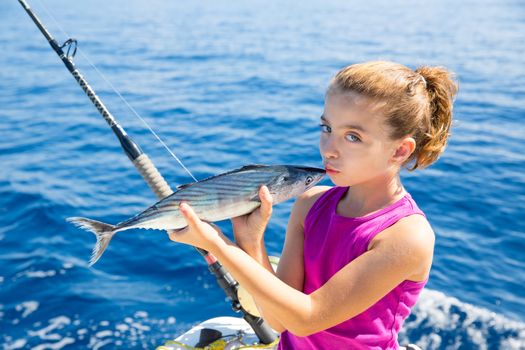 kid girl fishing tuna bonito sarda kissing fish for release due little size