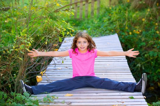 Kid girl in autumn deck smiling with braces open arms and legs outdoor