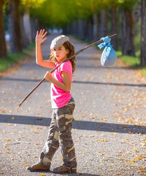 little kid with hobo stick bag and bundle girl saying goodbye with hand