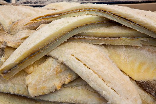 Cod fish salted codfish in a row stacked in market