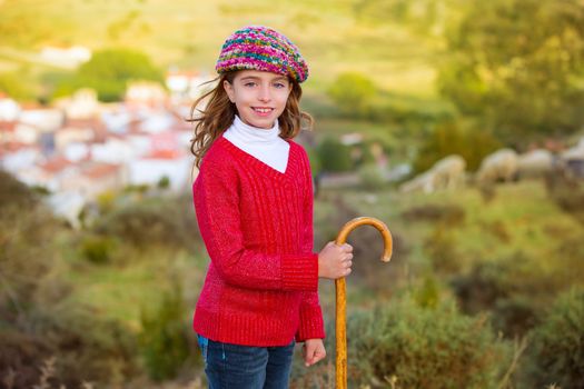 Kid girl shepherdess smiling with wooden baston in Spain village