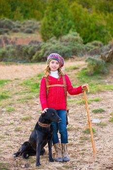 Kid girl shepherdess happy with dog flock of sheep and wooden stick in Spain