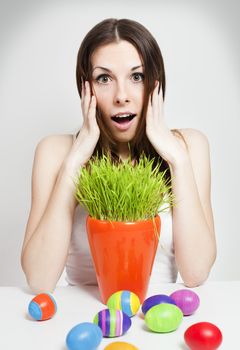Amazed woman with easter eggs and green grass