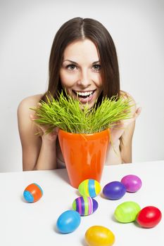 Excited woman searching for easter eggs in green grass