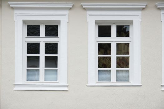 2 fast gleiche Fenster in heller Fassade
