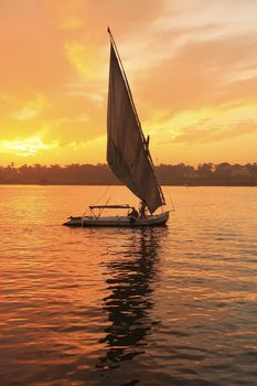 Felucca boat sailing on the Nile river at sunset, Luxor, Egypt