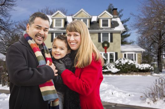 Happy Young Mixed Race Family in Front of Beautiful Snow Covered House.