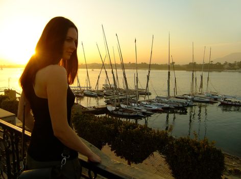 Young woman admiring sunset over the Nile river, Luxor, Egypt