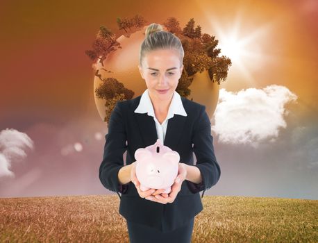 Composite image of blonde businesswoman holding pink piggy bank