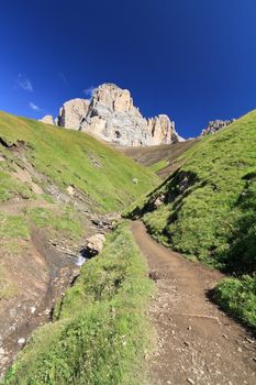 footpath beneath Sassolungo Mount on summer, Trentino, Italy
