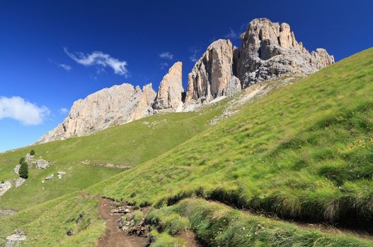 hiking beneath Sassolungo Mount on summer, Trentino, Italy