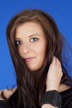 portrait of a beautiful young woman with brown hair - isolated on blue