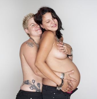 two happy lesbian women, one of them pregnant, happy becoming a family