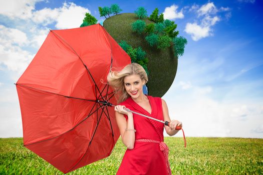 Composite image of smiling attractive blonde holding umbrella