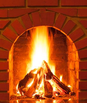 Burning fire in the brick fireplace, close up