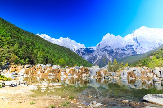 A view of a river and Jade Dragon Snow Mountain in Lijiang (Southwest China).