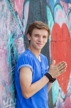 Portrait of happy teens boy having fun near painted wall