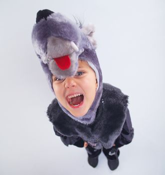 Little boy trying a carnival suit of wolf on the grey background