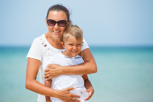 Closeup portrait of mother and son having fun on tropical beach