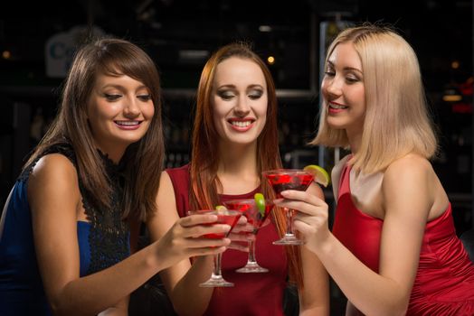 three girls raised their glasses in a nightclub, have fun with friends