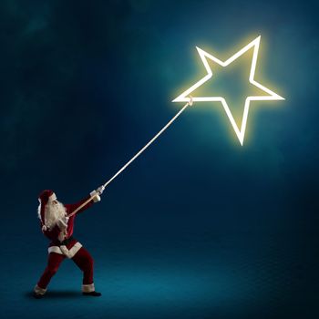 Santa Claus pulls the shining star using a rope