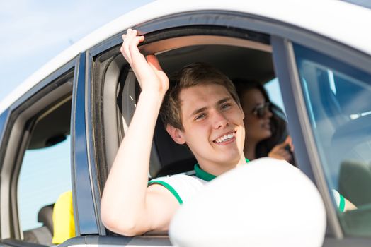 young man stuck his hand out of the window of the car, country car trip