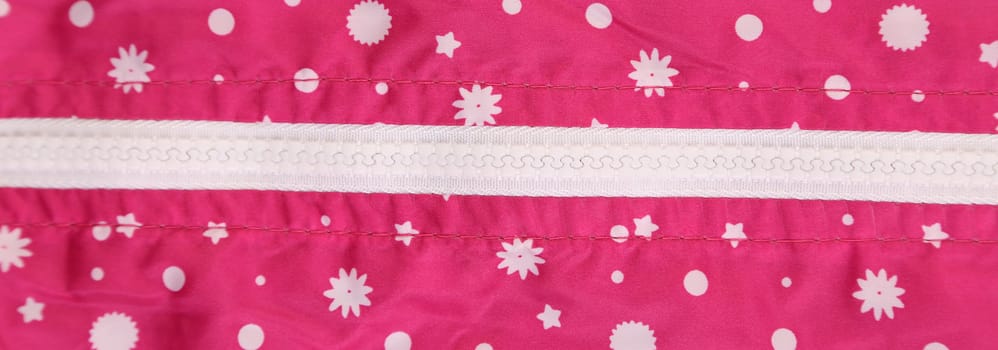 White zipper on the pink jacket with stars. Whole background.