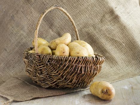 basket with potatoes  and jute background