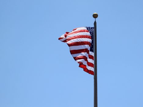 And old USA flag with a blue sky in the background.