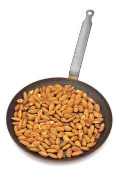 Pan with roasted almonds on white background