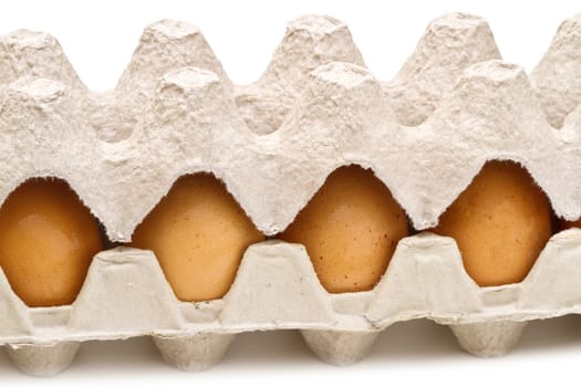 Brown eggs in a carton package on white background