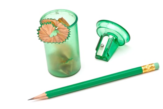 Green sharpener and pencil on white background.