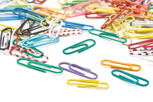 Colorful office paper clips closeup on white