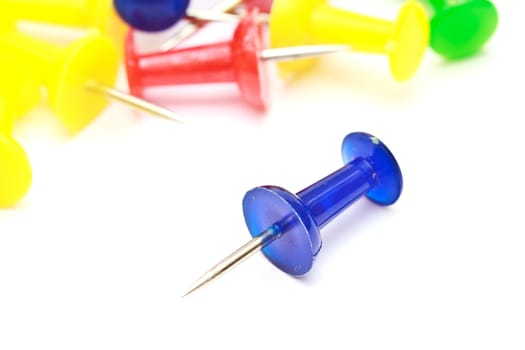 Colorful office push pins closeup on white