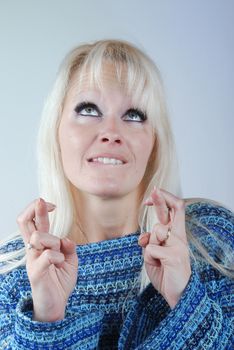 Young blond woman fingers crossed