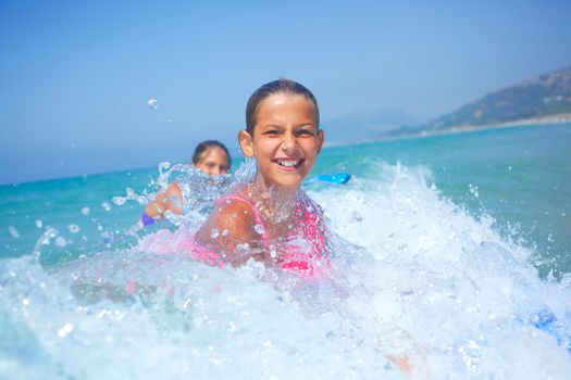 Summer vacation - Happy cute girl having fun with surfboard in the ocean