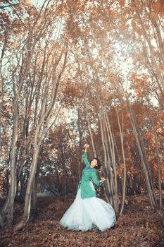 Brunette lady dancing in the autumn forest