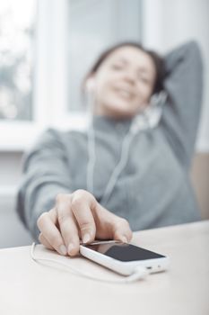 Smiling woman listening music from smartphone