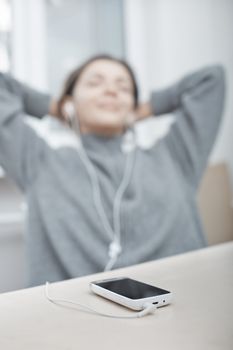 Smiling woman listening music from smartphone