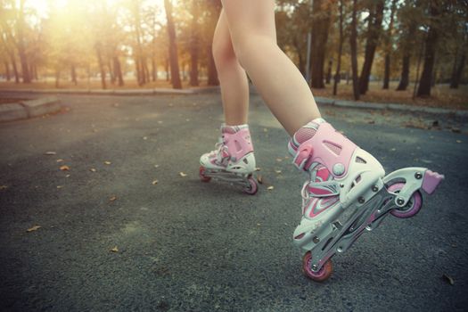 Legs of teenager having roller skate exercise in public park