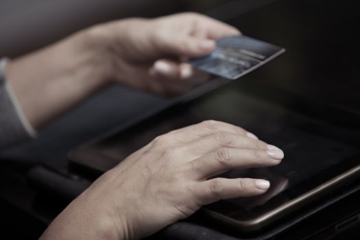 Woman hands holding credit card and tablet computer