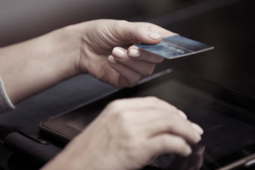 Woman hands holding credit card and tablet computer