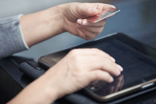 Human hand with digital tablet and credit card