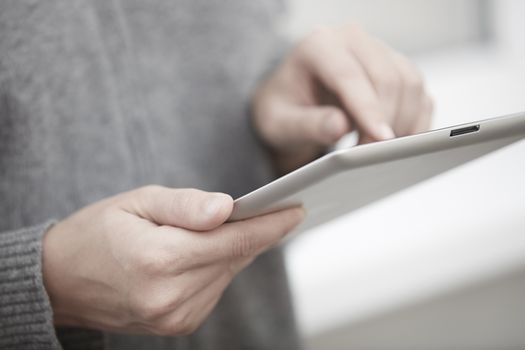 Woman with digital tablet surfing the web. Close-up view