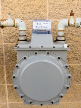 Residential natural gas meter on exterior wall to measure household energy consumption
