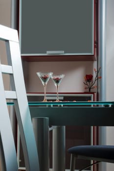 two wine glasses on a glass table in kitchen