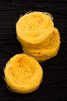 twirls pasta on a background of direct black spaghetti