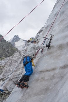 Girl climb up on the ice at glacier