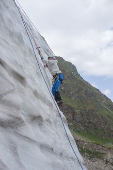 Girl climb up on the ice at glacier