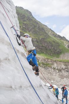 Girl climb up on the ice at glacier